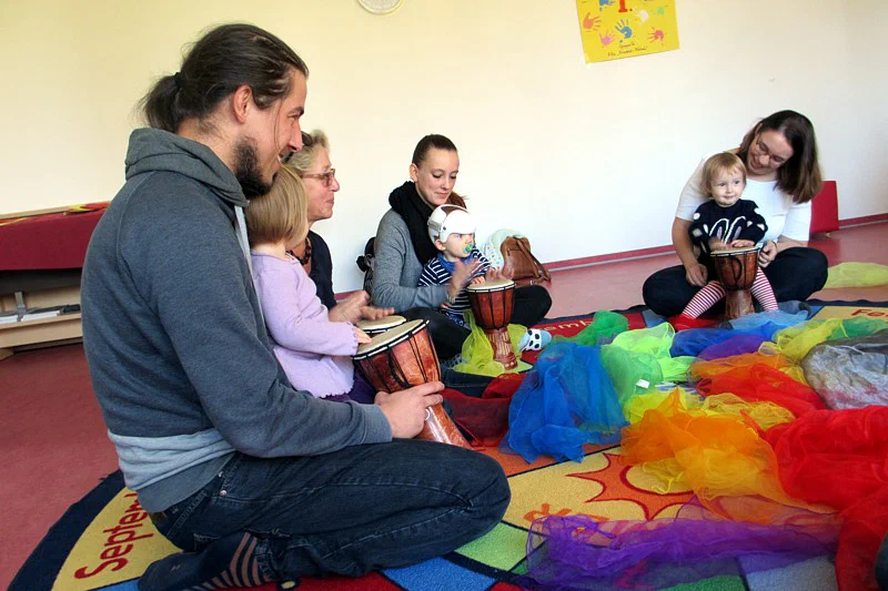 Kinder und Eltern spielen gemeinsam Instrumente in einem Musikkurs